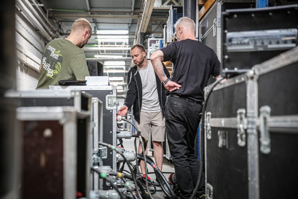 Techniciens Alive School en préparation autour des flight cases